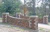 Drystone basalt entrance wall with sandstone coins and coping stones