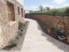 Drystone retaining wall with basalt stone house and sandstone coins and sills