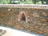 Basalt drystone appearance wall with sandstock brick coping